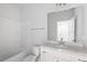 Bathroom with white single sink vanity, white tub, and shower, with a towel bar on the wall at 112 Central Townes Way # 294, Raleigh, NC 27603