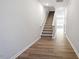 Hallway with wood flooring leading to carpeted stairs and an open area filled with light at 112 Central Townes Way # 294, Raleigh, NC 27603