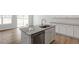 Kitchen island features a stainless steel dishwasher, granite countertop, white cabinets, and a stainless steel sink at 112 Central Townes Way # 294, Raleigh, NC 27603