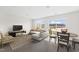 Living room with large windows, hardwood floors, sectional sofa, and a dining table at 112 Central Townes Way # 294, Raleigh, NC 27603