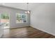 Bright dining area with hardwood floors, chandelier, and natural light from sliding glass door and window at 116 Central Townes Way # 293, Raleigh, NC 27603