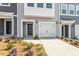 Close-up of a townhouse with a one-car garage, concrete driveway, and dark front door at 116 Central Townes Way # 293, Raleigh, NC 27603