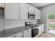 Contemporary kitchen boasts white subway tile backsplash, gray countertops, stainless steel oven and microwave at 116 Central Townes Way # 293, Raleigh, NC 27603