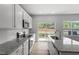 Modern kitchen features white cabinets, granite countertops, stainless steel appliances, and hardwood floors at 116 Central Townes Way # 293, Raleigh, NC 27603