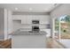 Well-lit kitchen featuring stainless appliances, island, white cabinets, and granite counters at 116 Central Townes Way # 293, Raleigh, NC 27603