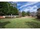 Lush backyard featuring a serene pond, manicured landscaping, and verdant grass at 12132 Lockhart Ln, Raleigh, NC 27614