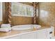 The bathtub boasts a jacuzzi tub, mosaic tile accents, decorative pillars, and natural light at 12132 Lockhart Ln, Raleigh, NC 27614