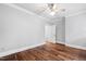 Empty bedroom with hardwood floors, neutral walls, ceiling fan, and a door leading to another room at 12132 Lockhart Ln, Raleigh, NC 27614