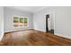 Bedroom featuring natural light from a large window and hardwood floors that lead to an ensuite bathroom at 12132 Lockhart Ln, Raleigh, NC 27614