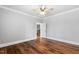 Empty bedroom with hardwood floors, and a view of the staircase to the second level at 12132 Lockhart Ln, Raleigh, NC 27614