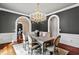 Chandelier lit dining room, featuring dark walls, white trim and arched entryways at 12132 Lockhart Ln, Raleigh, NC 27614