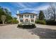 Stately two-story home with a circular driveway featuring a beautiful fountain and lush landscaping at 12132 Lockhart Ln, Raleigh, NC 27614