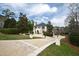 Exterior showcases lush landscaping, stamped concrete driveway, and elegant architectural details at 12132 Lockhart Ln, Raleigh, NC 27614