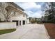 Exterior view of the home featuring an attached two-car garage, a spacious driveway, and beautifully landscaped surroundings at 12132 Lockhart Ln, Raleigh, NC 27614
