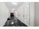 Long hallway with dark marble floors, elegant white walls and trim, and several closed doors at 12132 Lockhart Ln, Raleigh, NC 27614