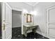 Elegant powder room featuring a decorative mirror, marble countertop, and black and white tile floors at 12132 Lockhart Ln, Raleigh, NC 27614