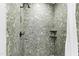 Stylish shower featuring green stone tile and a convenient built-in shelf at 12132 Lockhart Ln, Raleigh, NC 27614