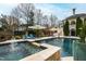 Sparkling in-ground pool features a tanning ledge, stone accents, and professional landscaping at 12132 Lockhart Ln, Raleigh, NC 27614