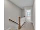 Hallway with carpeted floor, white walls, and wooden handrail along the staircase at 1249 S Blount Street # 101, Raleigh, NC 27601