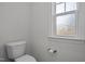 Bright bathroom featuring toilet, textured privacy window and silver fixtures at 1254 White Flint Cir, Durham, NC 27703