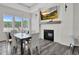 Comfortable dining area with a fireplace, TV, large windows overlooking the pool, and modern furniture at 1254 White Flint Cir, Durham, NC 27703