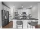 Modern kitchen features stainless steel appliances, a center island with seating, and access to the laundry room at 1254 White Flint Cir, Durham, NC 27703