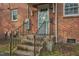 Brick home's exterior entrance with stairs and metal railing, blending traditional charm at 127 Wilkinson St, Rocky Mount, NC 27804
