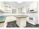 A bright, classic kitchen with white cabinets, an island, and modern appliances at 127 Wilkinson St, Rocky Mount, NC 27804