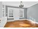 A well-lit living room with hardwood floors, classic chandelier, and large windows with blinds at 127 Wilkinson St, Rocky Mount, NC 27804