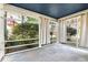 Enclosed porch area with slate flooring and blue ceiling offers tranquil views of surrounding greenery at 127 Wilkinson St, Rocky Mount, NC 27804