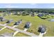 Aerial view showcases the neighborhood's homes in a well-maintained community with expansive grassy yards and a tranquil pond at 147 Young Farm Dr, Lillington, NC 27546