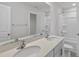 Bathroom featuring double sink vanity with quartz countertop and large mirror. Bathtub in the background at 147 Young Farm Dr, Lillington, NC 27546