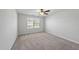 Well-lit bedroom with neutral carpeting, ceiling fan, and a window offering outdoor views at 147 Young Farm Dr, Lillington, NC 27546