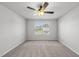Bright, carpeted bedroom with ceiling fan and a large window offering natural light and outdoor views at 147 Young Farm Dr, Lillington, NC 27546