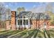 Brick home featuring a brick chimney, back deck, and a nice lawn at 1532 Rockwood Downs Dr, Wendell, NC 27591