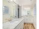 Bright bathroom with double sinks, granite countertop, and wooden floor at 1532 Rockwood Downs Dr, Wendell, NC 27591
