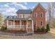 Charming two-story brick home with a welcoming front porch and red shutters at 1532 Rockwood Downs Dr, Wendell, NC 27591