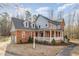 Spacious two-story home with brick and siding, featuring a large wrap-around porch at 1532 Rockwood Downs Dr, Wendell, NC 27591