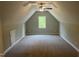 An attic bedroom with sloped ceilings, neutral walls, carpet, and a window that offers a cozy and private retreat at 162 Kirkwall Ln, Selma, NC 27576