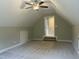 An attic bedroom with carpet and sloped ceilings, featuring access steps that create a private and versatile space at 162 Kirkwall Ln, Selma, NC 27576