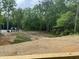 View of a partially wooded backyard showing the topsoil prepped for landscaping at 162 Kirkwall Ln, Selma, NC 27576