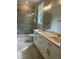 A spacious bathroom featuring a double sink vanity with white cabinets, complemented by a frameless glass shower at 162 Kirkwall Ln, Selma, NC 27576