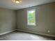 Bedroom with plush carpet, neutral walls, a window, and trim detail that creates a blank canvas to customize at 162 Kirkwall Ln, Selma, NC 27576
