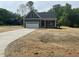 A home with a driveway, attached garage, a red door, and contrasting trim and siding at 162 Kirkwall Ln, Selma, NC 27576