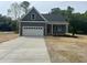 Charming single-Gathering home boasts a well-manicured lawn, attached two-car garage and welcoming red front door at 162 Kirkwall Ln, Selma, NC 27576