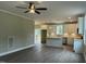 Open-concept kitchen flows seamlessly into the living area, featuring a ceiling fan and access to the outdoors at 162 Kirkwall Ln, Selma, NC 27576