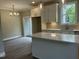 Open kitchen and dining area featuring white cabinets, wood floors, a stylish chandelier, and easy access to outside at 162 Kirkwall Ln, Selma, NC 27576