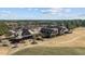 An aerial view captures the clubhouse and its expansive grounds, featuring manicured lawns and wooded areas at 1637 Hasentree Villa Ln, Wake Forest, NC 27587