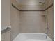 Clean bathroom featuring a combined tub and shower, neutral tile, and chrome fixtures at 1637 Hasentree Villa Ln, Wake Forest, NC 27587