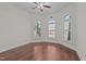 Bright bedroom featuring hardwood floors, large arched windows with shutters, and a modern ceiling fan at 1637 Hasentree Villa Ln, Wake Forest, NC 27587